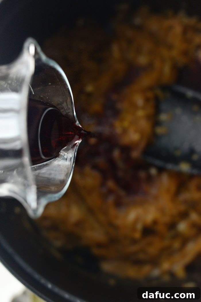 Sweet Onion Braised Beef 12 Adding dry red wine to caramelized onions in a Dutch oven for deglazing.