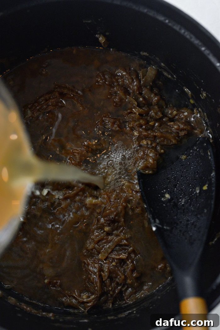 Sweet Onion Braised Beef 15 Pouring low-sodium beef broth into the Dutch oven with onions and flour.