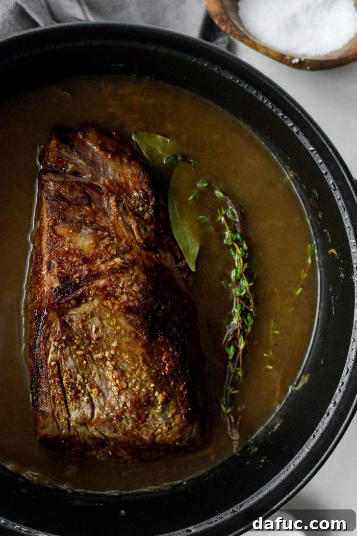 Sweet Onion Braised Beef 17 Placing seared chuck roast, bay leaves, and fresh thyme into the Dutch oven with gravy.