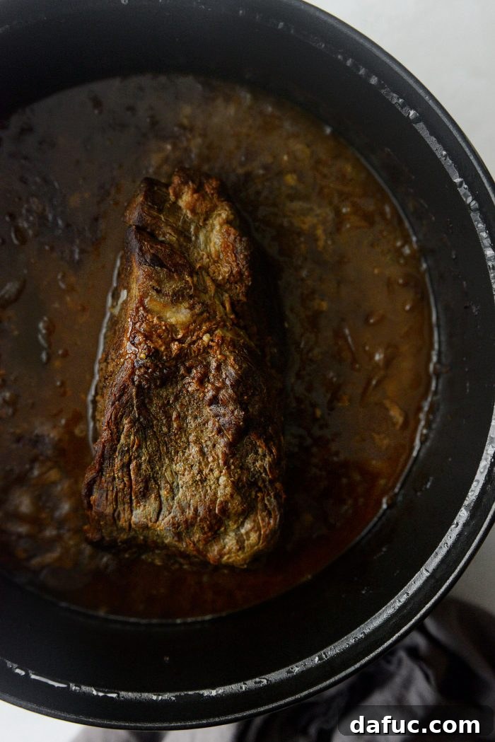 Sweet Onion Braised Beef 19 Removing and discarding bay leaves and thyme stems from the cooked pot roast.