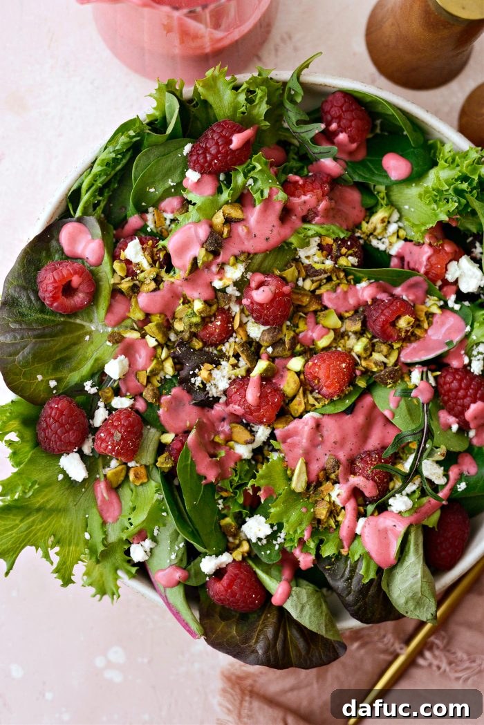Ruby Red and Green Pistachio Salad 8 Raspberry Pistachio Salad being drizzled with homemade raspberry walnut vinaigrette