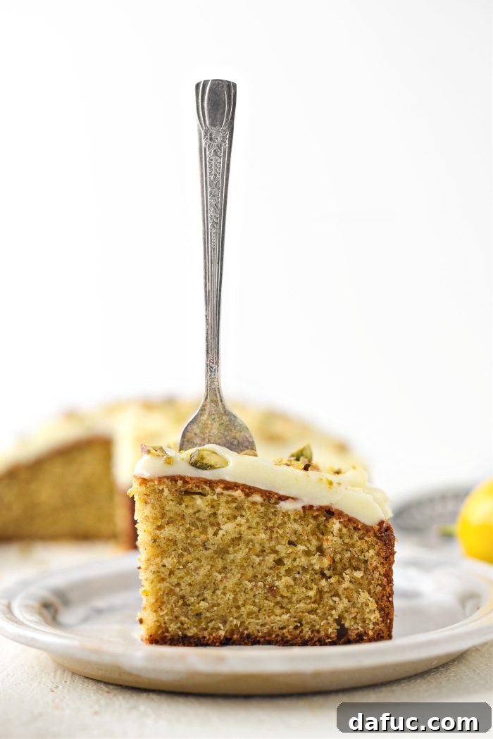 Another appealing angle of a Lemon Pistachio Cake, highlighting its texture and frosting