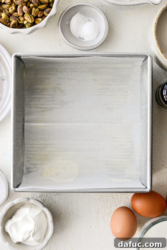 Oven preheating and an 8x8 metal baking pan lined with parchment paper