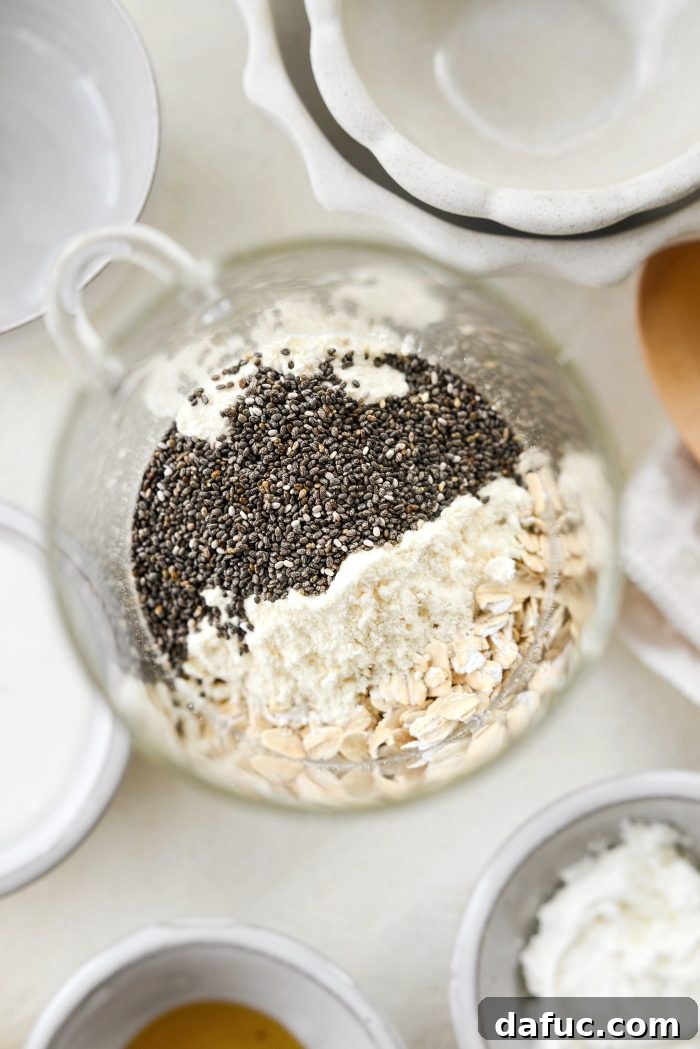 Oats, protein powder, and chia seeds being added to a jar
