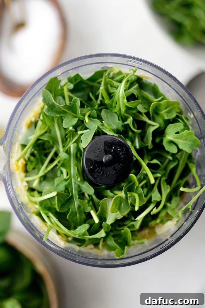 Creamy Artichoke Arugula Dip 6 Adding baby arugula in batches to the food processor.