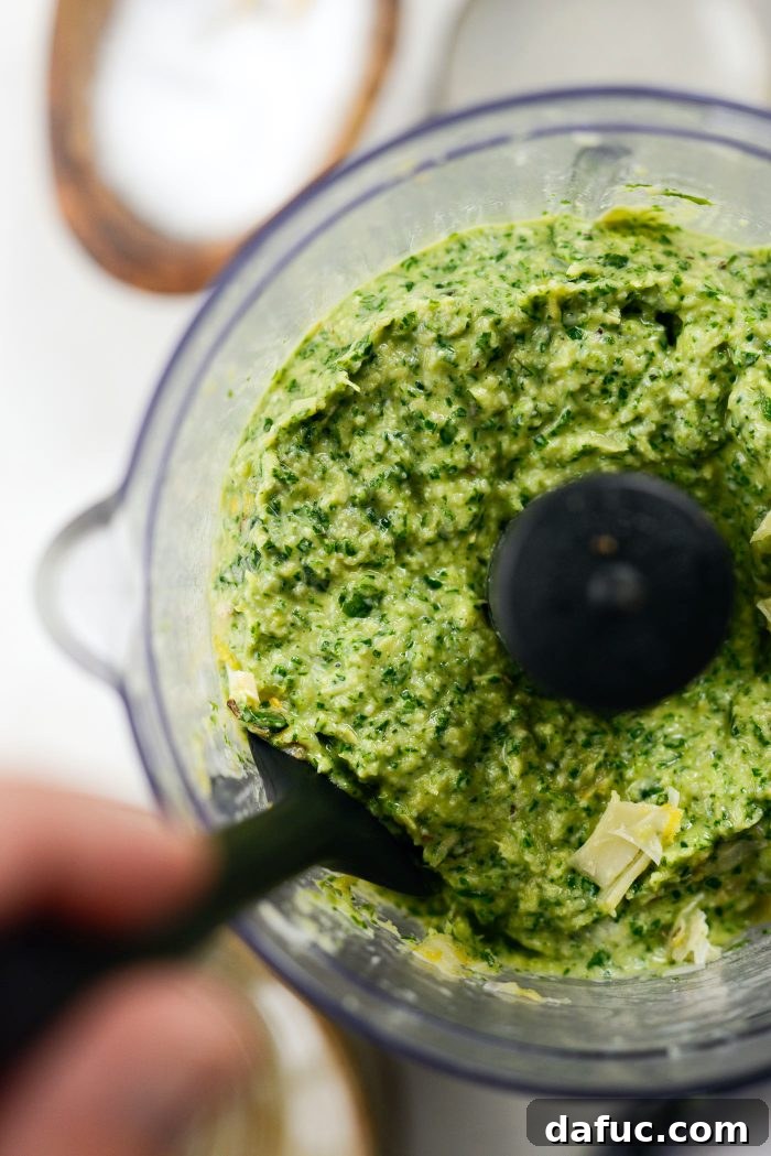 Creamy Artichoke Arugula Dip 9 Scraping down the sides of the food processor bowl to ensure all ingredients are blended.