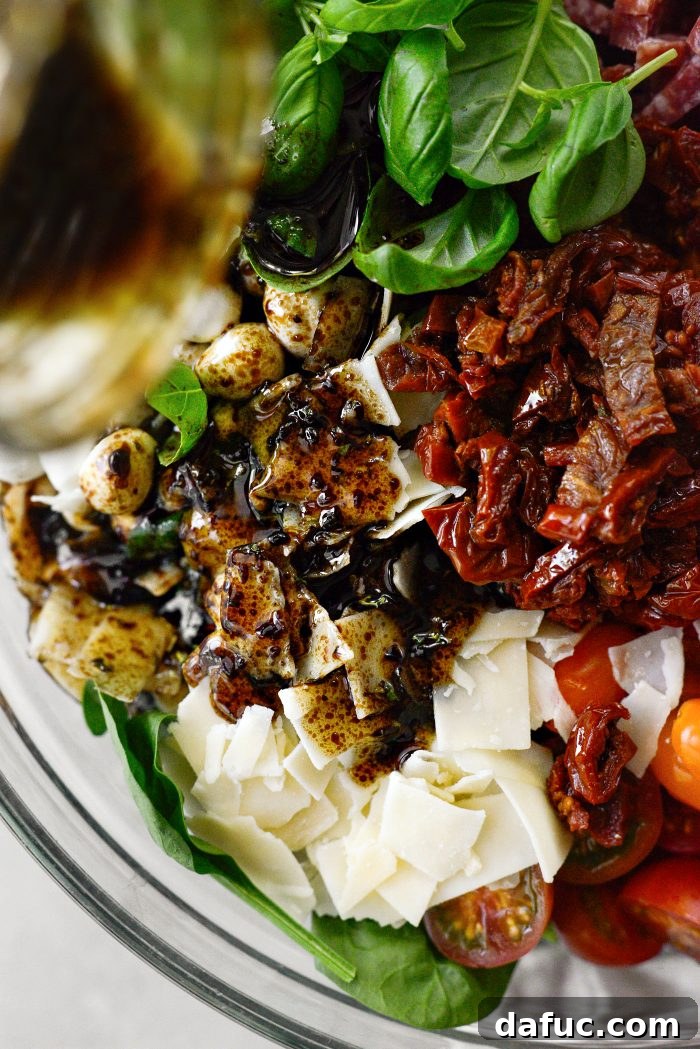 Rustic Tuscan Tortellini Salad 12 Pouring balsamic dressing over the pasta salad ingredients