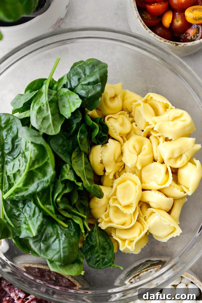 Rustic Tuscan Tortellini Salad 10 Drained tortellini added to a bowl with baby spinach