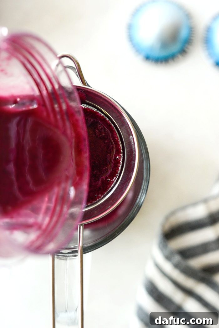 Straining homemade blueberry syrup