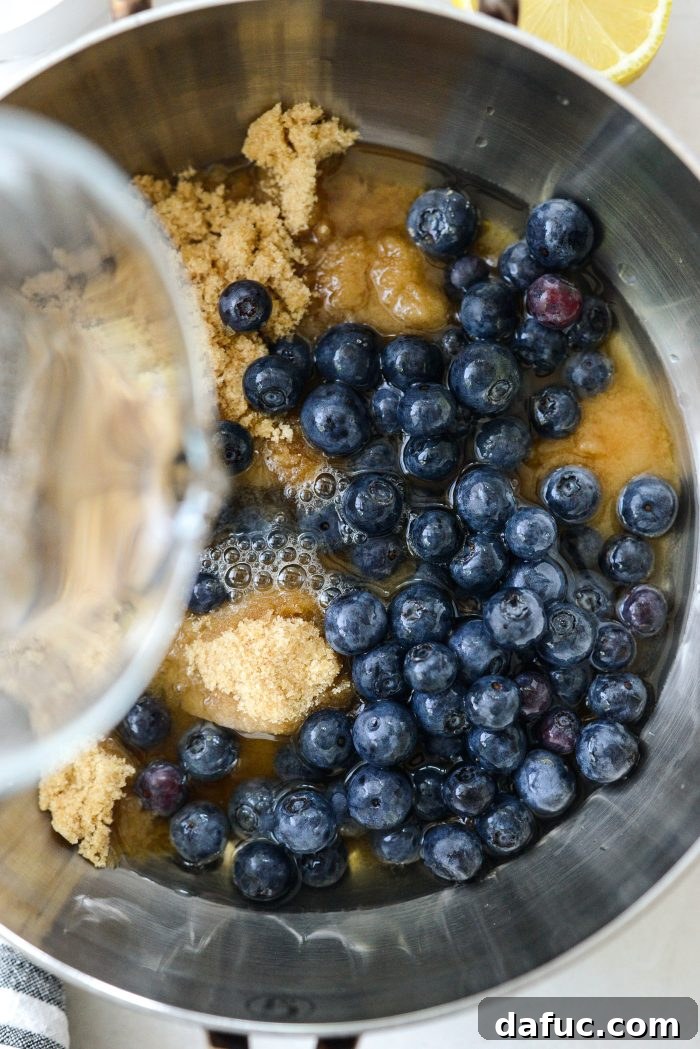Pouring water into blueberry mixture