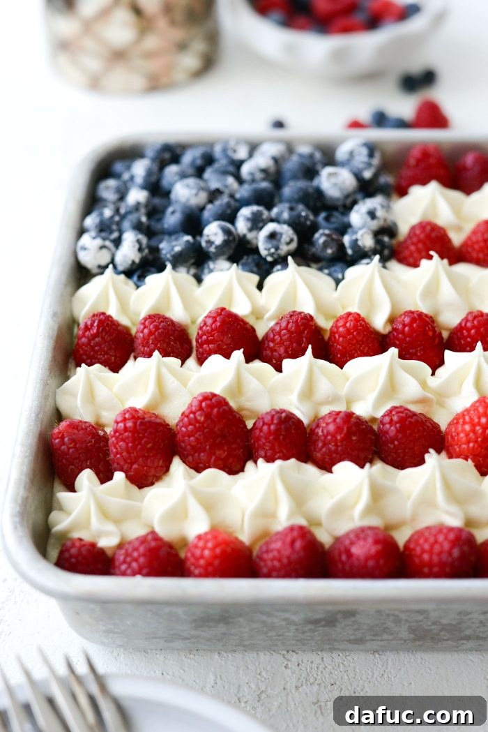 Piping buttercream stars between raspberry stripes on the American Flag Cake.