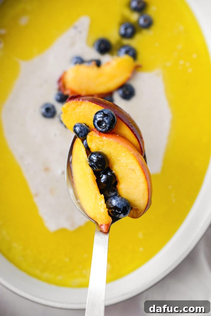 spoon peaches and blueberries and some of the liquids over top of the batter