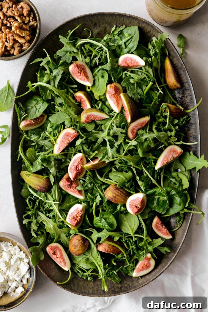 Arranging mixed greens on a serving platter to build the salad