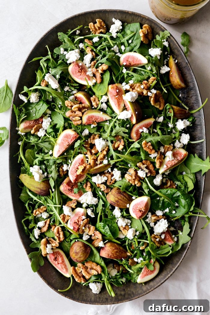 Topping the fig salad with toasted walnuts and crumbled goat cheese