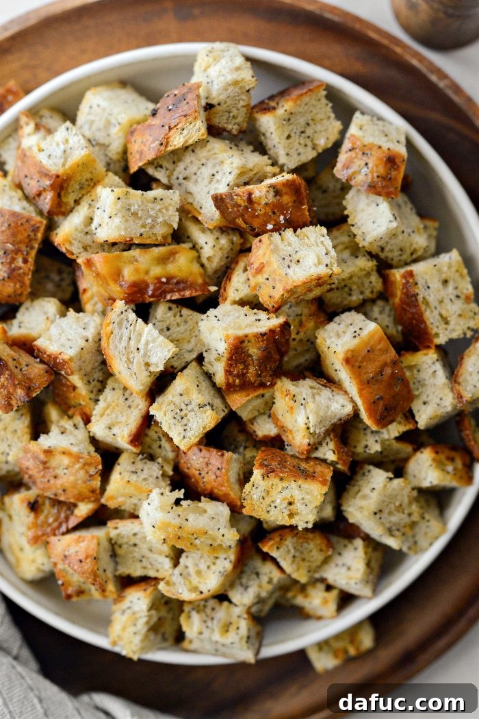 Golden Crispy Homemade Croutons 10 A charming close-up of a bowl of homemade croutons with a rustic wooden spoon, ready for enjoyment