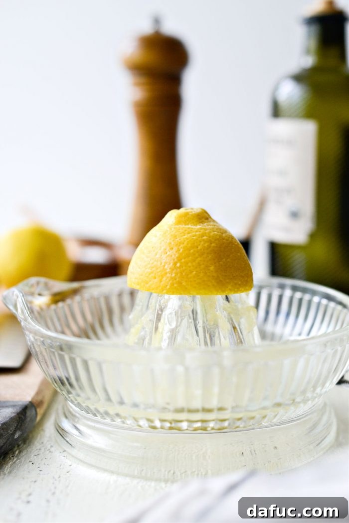Lemons being juiced to extract fresh lemon juice for the dressing