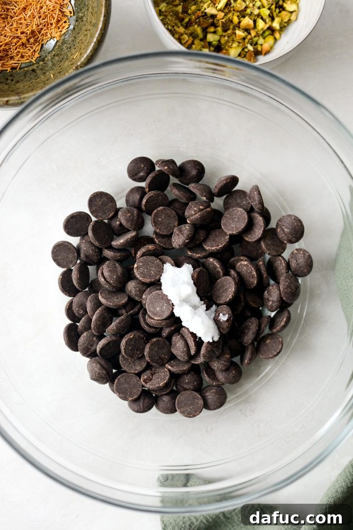 Bittersweet chocolate chips and coconut oil in a bowl, ready for melting