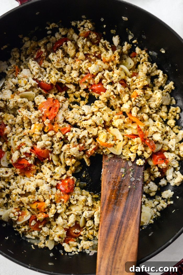 Stirring the chicken and tomato mixture until tomatoes burst