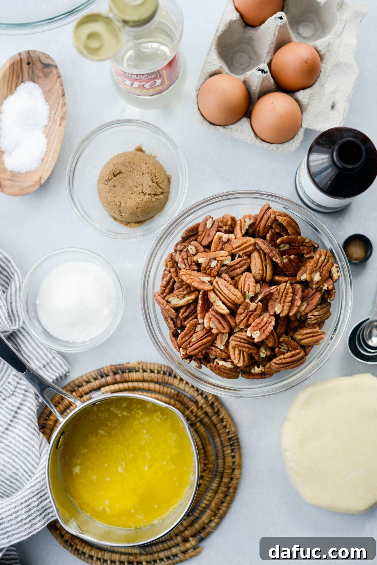 Irresistible Classic Pecan Pie 4 Pecan Pie ingredients laid out including eggs, syrup, sugars, butter, vanilla, salt, and pecans