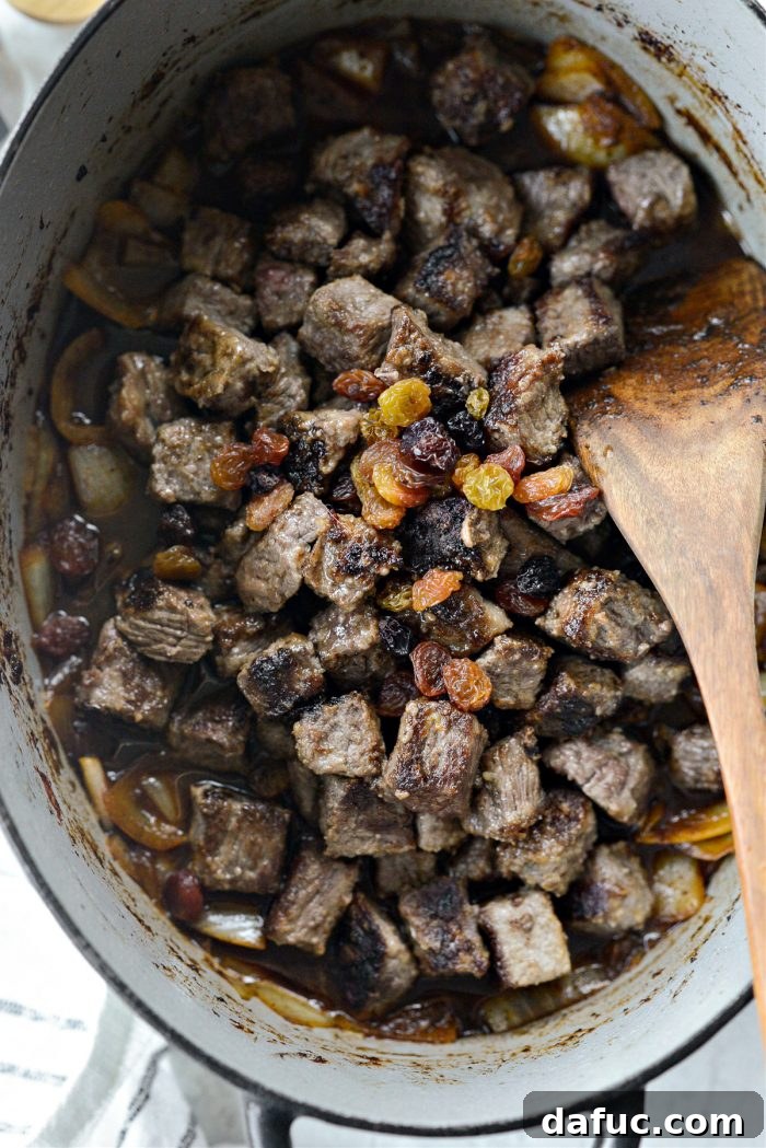 Guinness-Infused Irish Beef Stew 21 Adding browned beef and golden raisins back into the pot