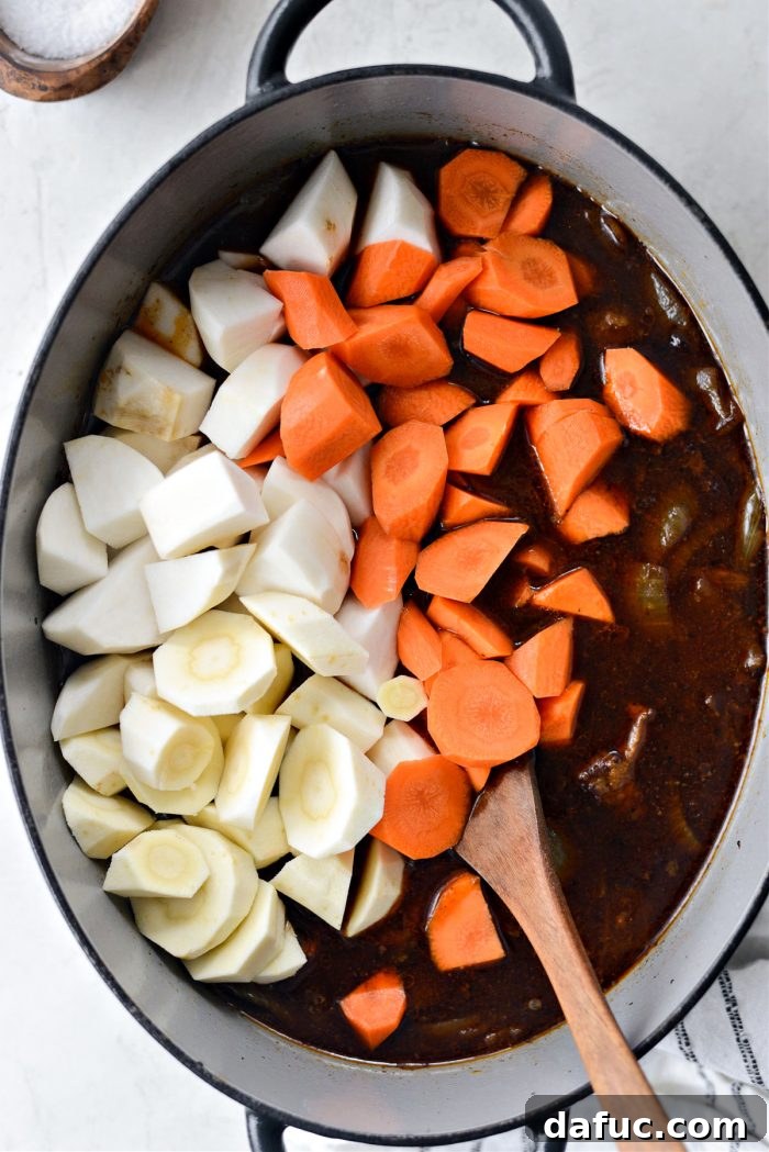 Guinness-Infused Irish Beef Stew 26 Adding prepared root vegetables to the simmering stew
