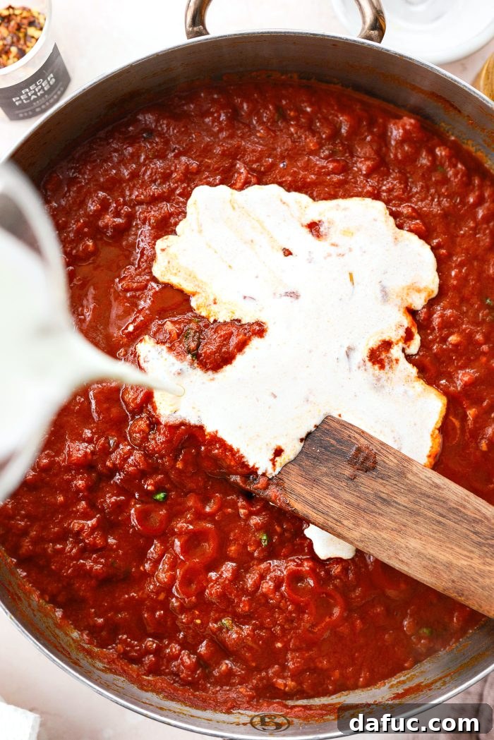Creamy Blush Pasta 18 Pouring heavy cream into the simmering pink pasta sauce