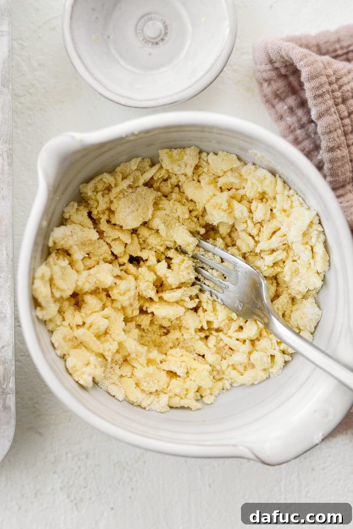 Mixing streusel ingredients with a fork until small crumbs form