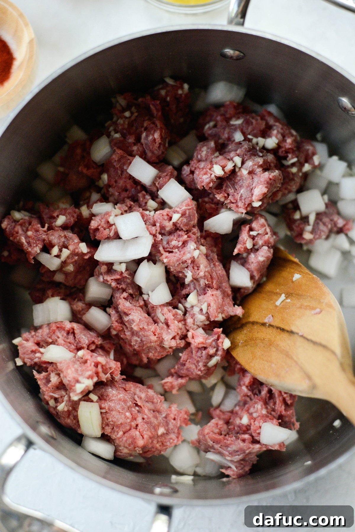 Chili Preparation Step 1 Ground beef, diced onion, and minced garlic in a pot, ready to cook