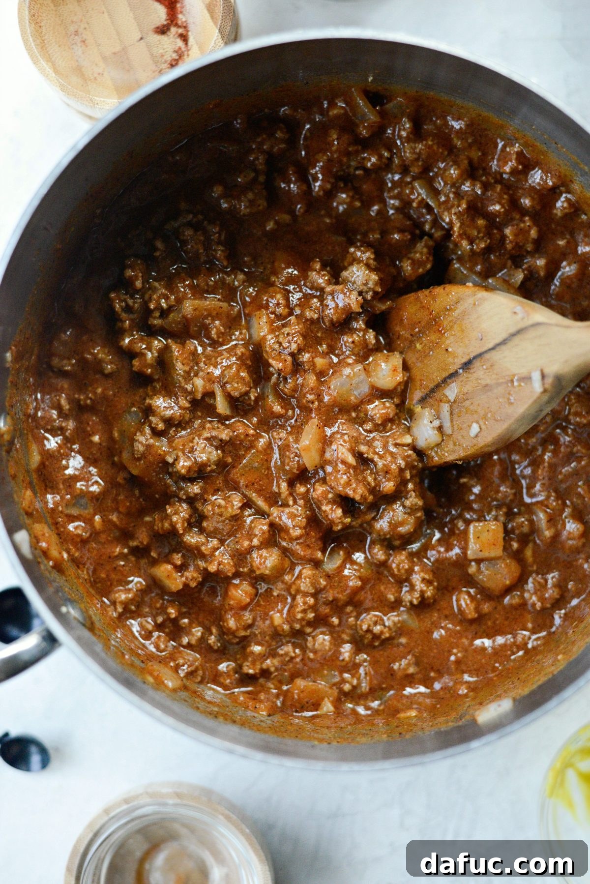 Adding Spices and Tomato Puree Adding spices and tomato puree to the ground beef mixture