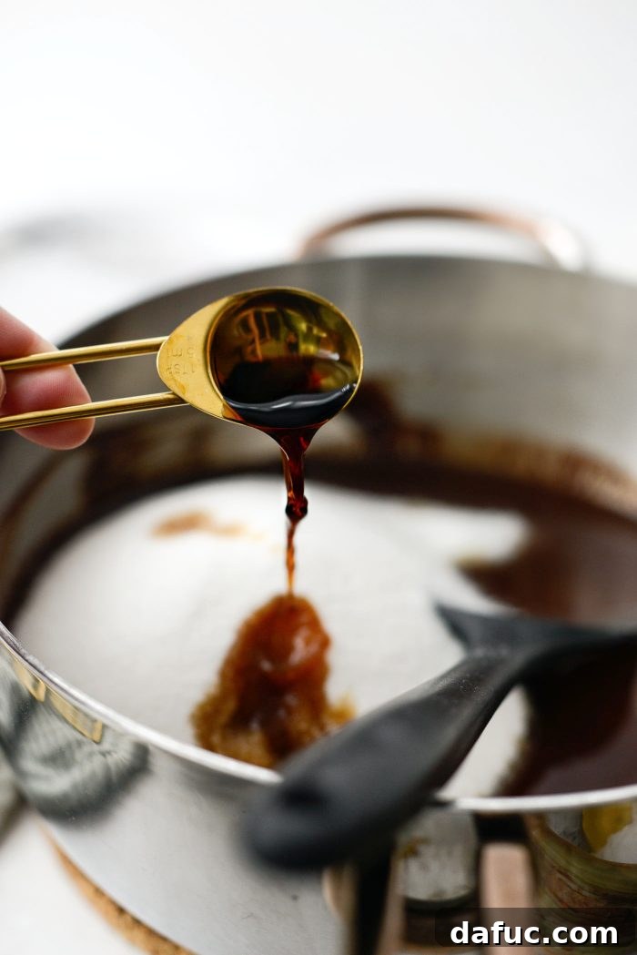 Pouring pure vanilla extract into the rich brownie wet mixture