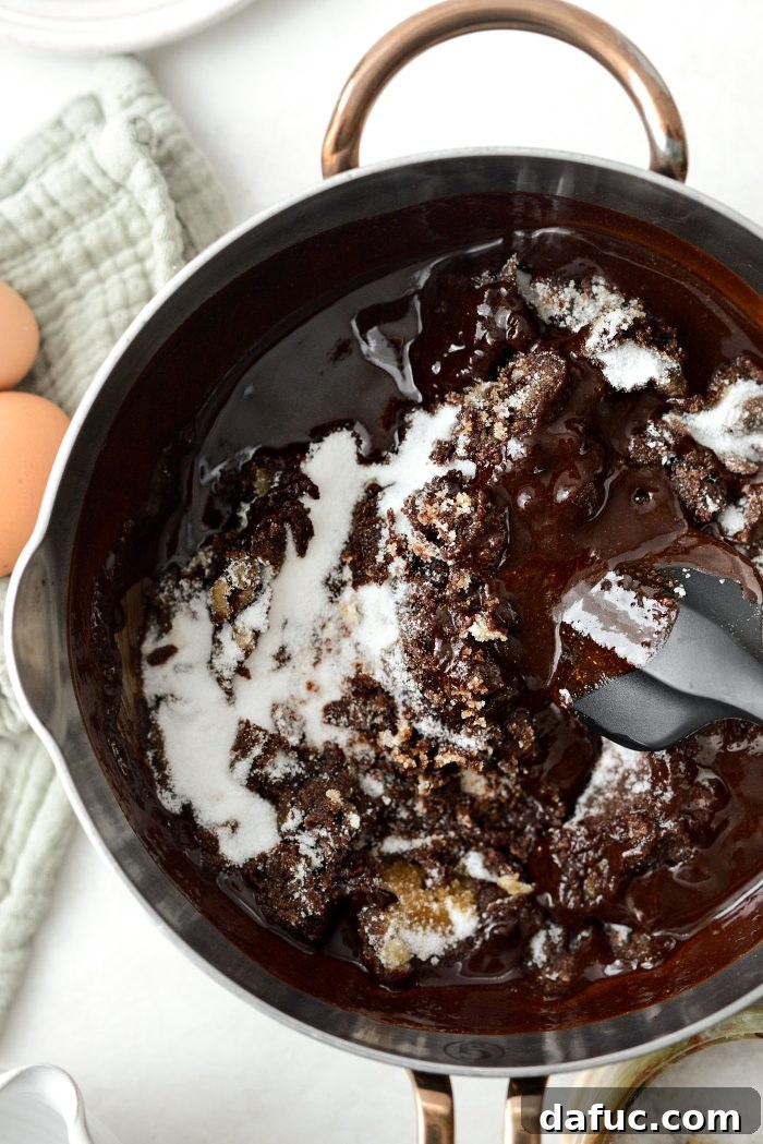 Stirring the sugar and vanilla into the melted chocolate mixture until well blended