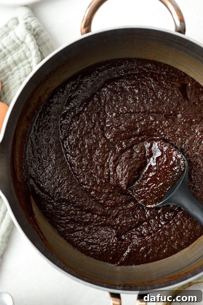 The glossy, thick, and well-emulsified brownie wet mixture after adding all eggs
