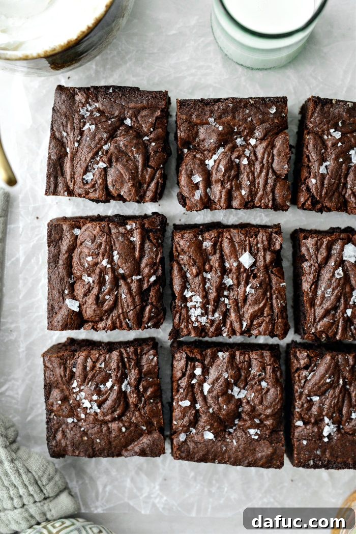 A stack of Salted Fudge Brownies, showcasing their rich texture and flaky salt topping