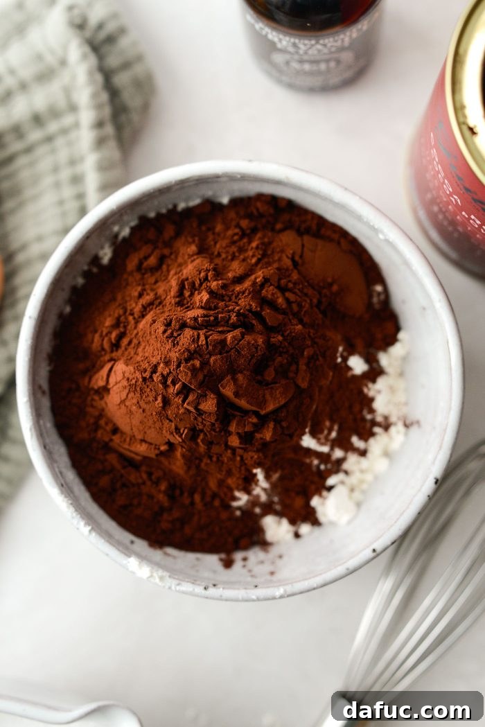 Measuring and combining all-purpose flour and unsweetened cocoa powder in a mixing bowl