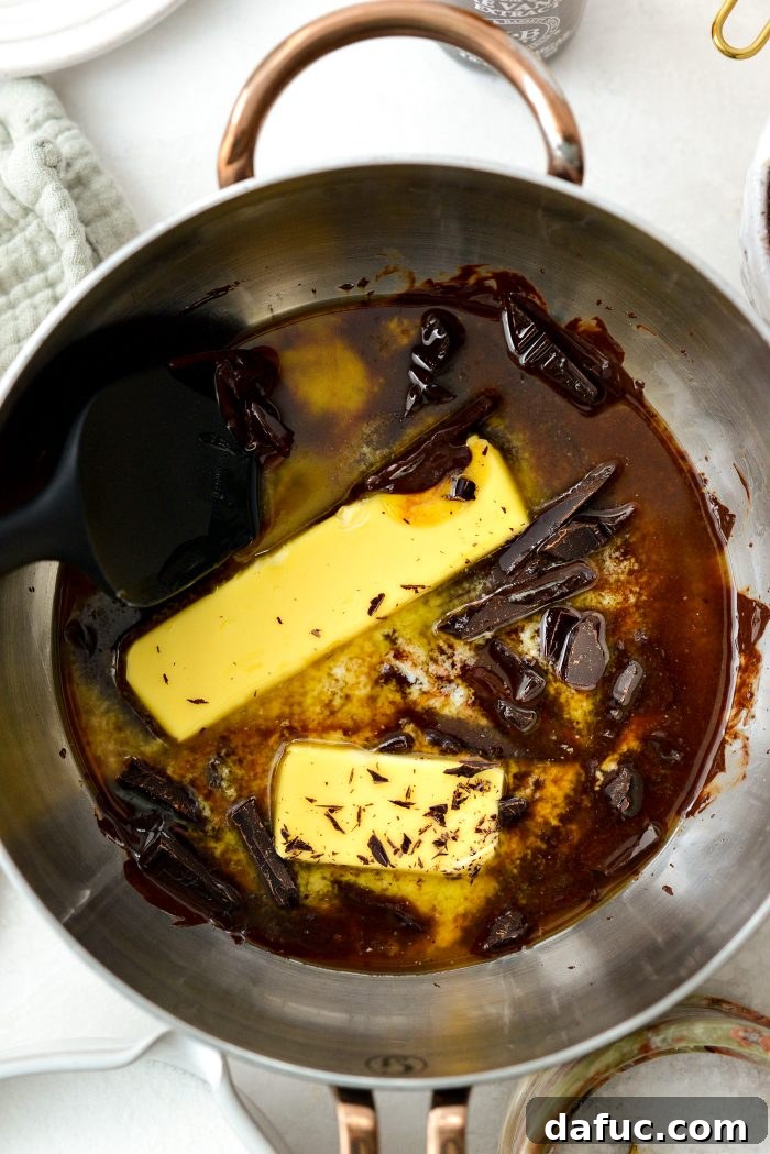 Unsalted butter and chopped unsweetened chocolate melting gently in a saucepan