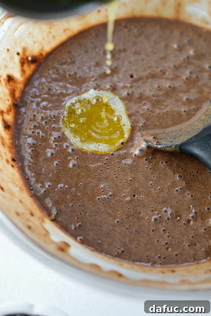 Adding melted butter to the chocolate cake batter