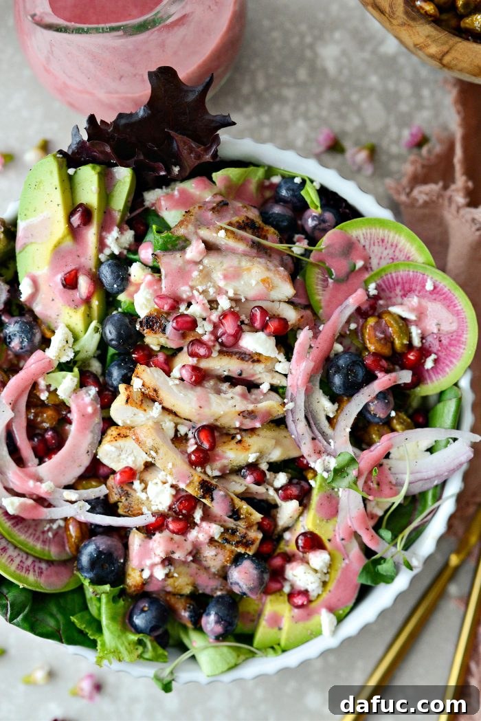 Overhead view of the dressed Blueberry Pistachio Spring Salad on a white platter.