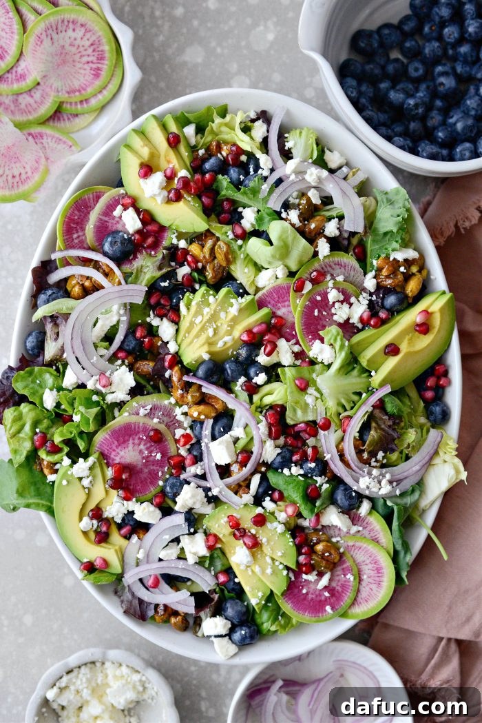 A large platter being prepared with salad greens and initial toppings for assembly.