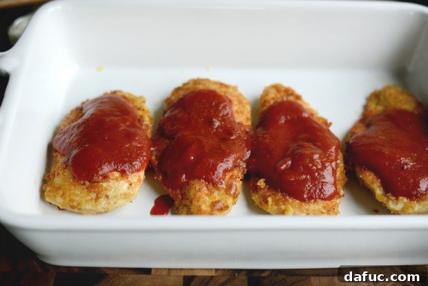 Pouring marinara sauce over chicken breasts
