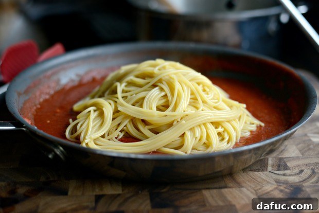 Spaghetti cooking in a pot of boiling water
