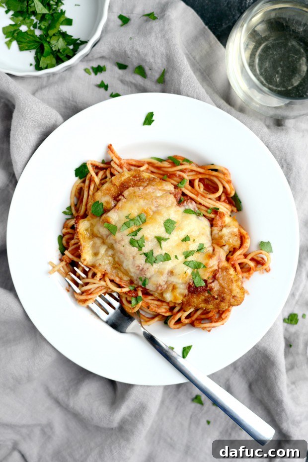 Plated Easy Chicken Parmesan with spaghetti and fresh basil