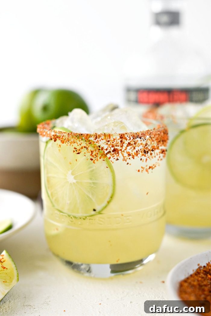 Two Honey Lime Margaritas garnished with lime wheels, ready to be served.