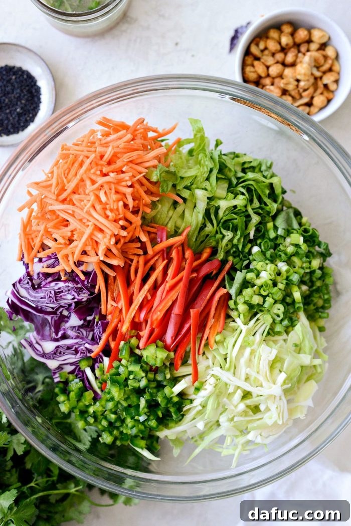 Asian Crunch Salad with Basil-Ginger Zing 8 Prepped ingredients for Asian Cabbage Slaw in a large glass mixing bowl
