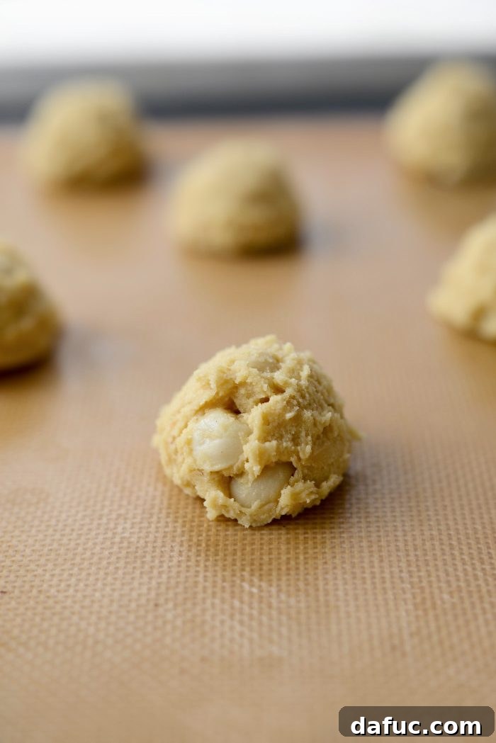 Gourmet White Chocolate Macadamia Nut Treasures 13 Scooping cookie dough mounds onto a prepared baking sheet