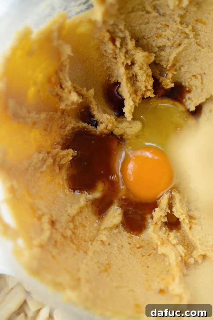 Gourmet White Chocolate Macadamia Nut Treasures 8 Adding eggs one at a time with vanilla extract
