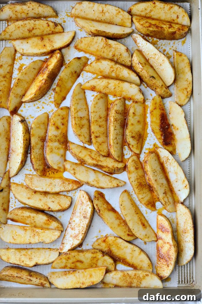 Crispy Seasoned Steak Fries 10 Wedges of seasoned potatoes arranged in a single, even layer on a parchment-lined baking pan