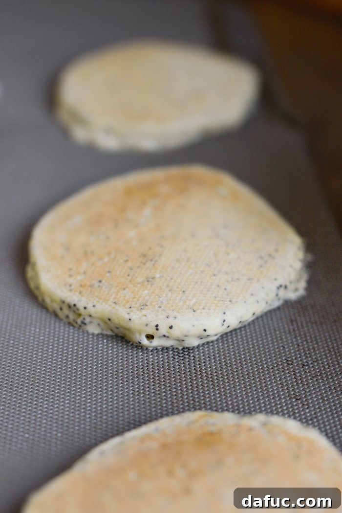 Flipping lemon poppy seed pancakes on the griddle