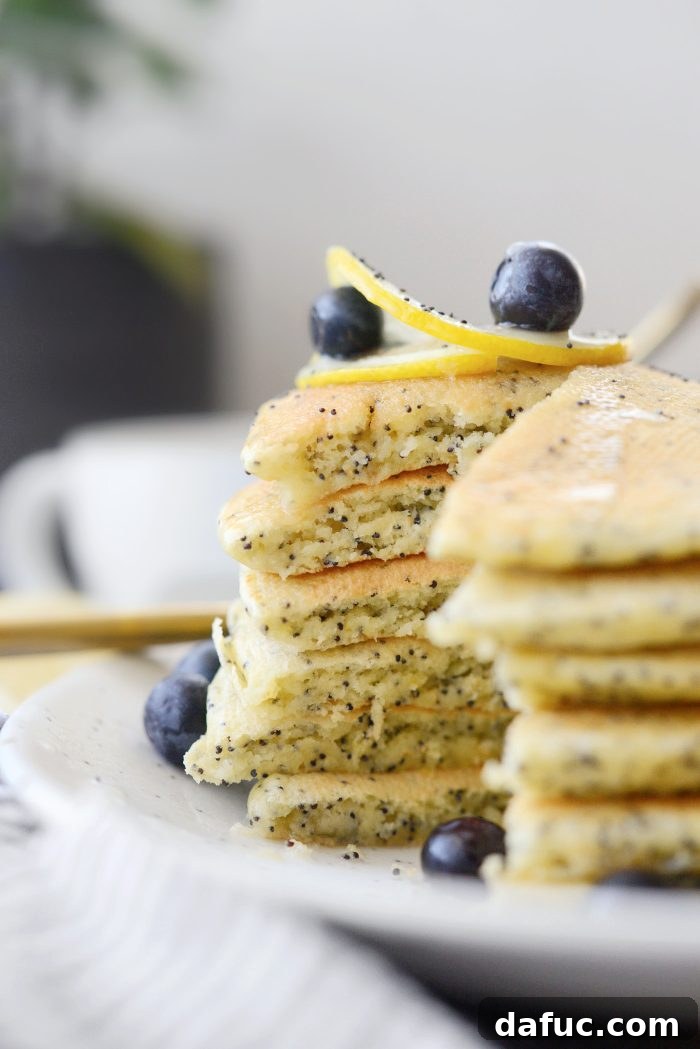 Freshly cooked Lemon Poppy Seed Pancakes with glaze and berries