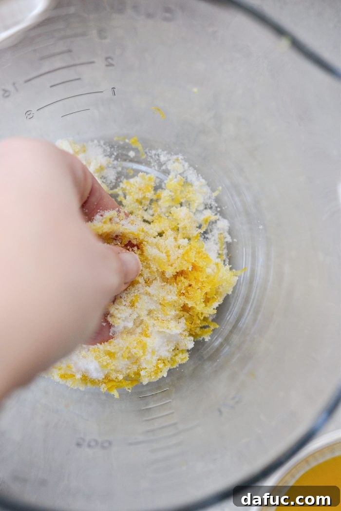 Rubbing lemon zest with sugar for enhanced flavor