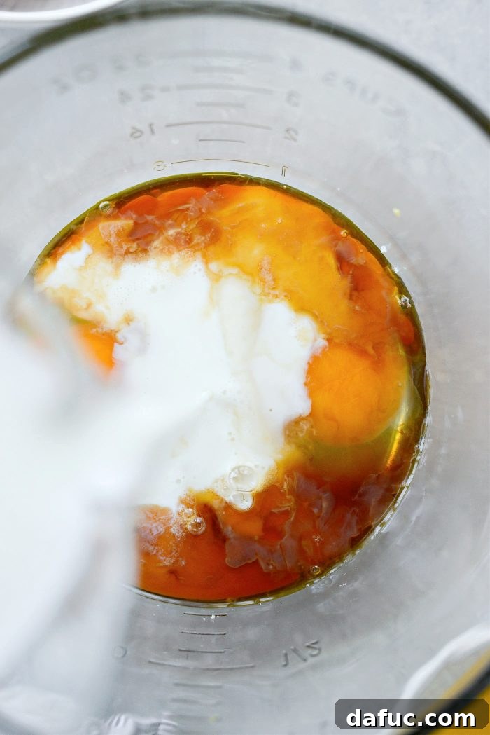Adding eggs, vanilla, lemon juice, and milk to lemon sugar